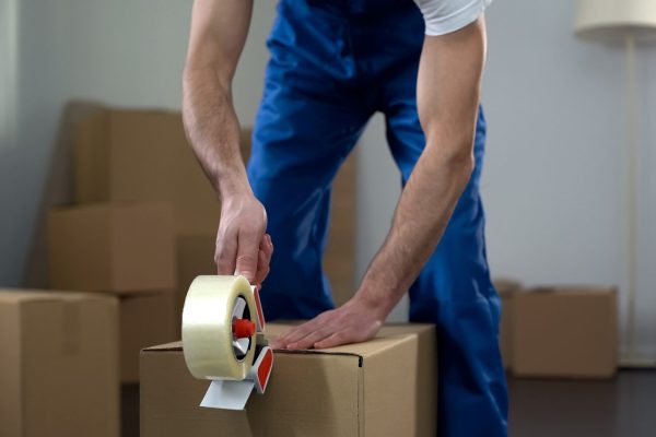 Moving Company Worker Packing Cardboard Boxes, Quality Delivery